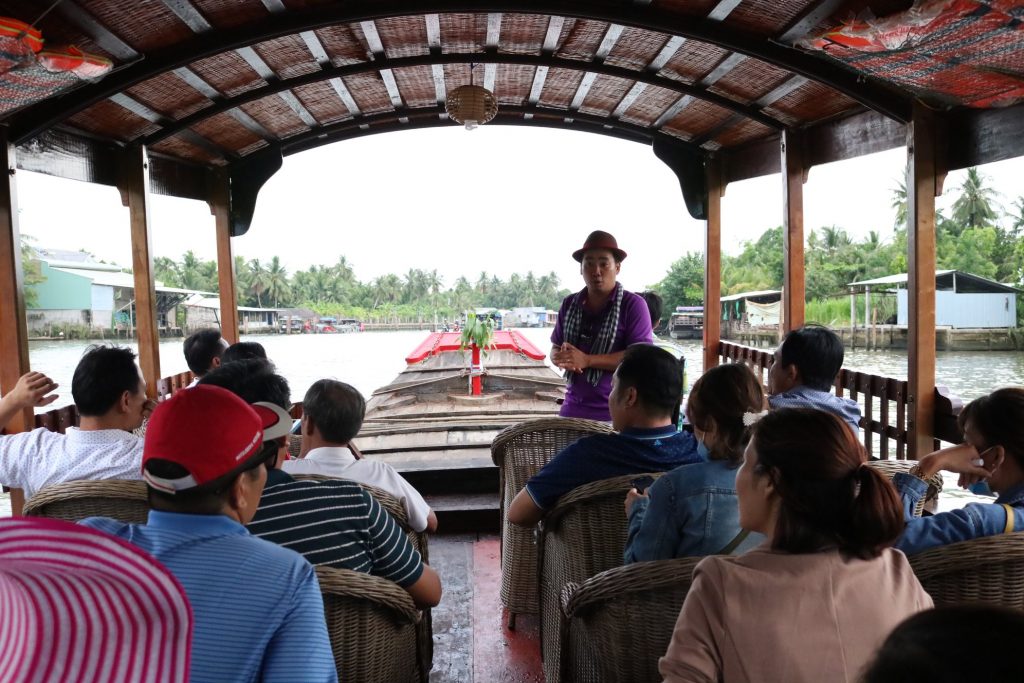 Du khách tham quan chợ dừa nổi song Thom trên thuyền